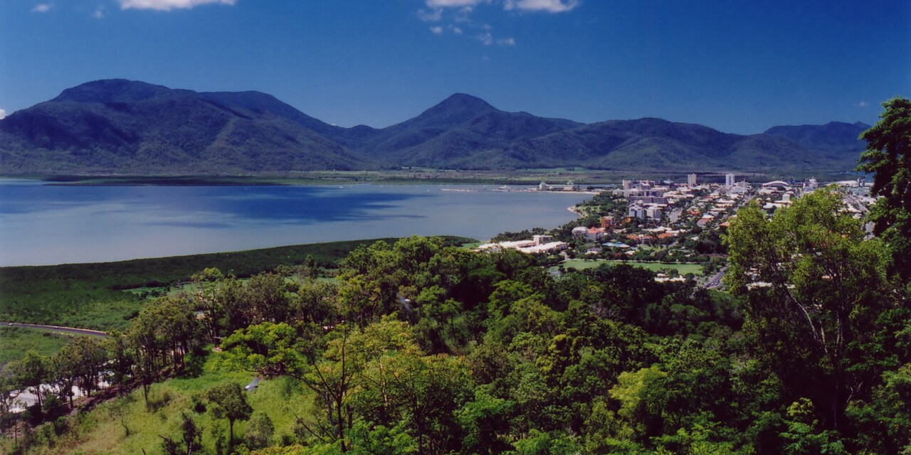 The city of Cairns, tucked between a mountain range, a lake and lush forest 