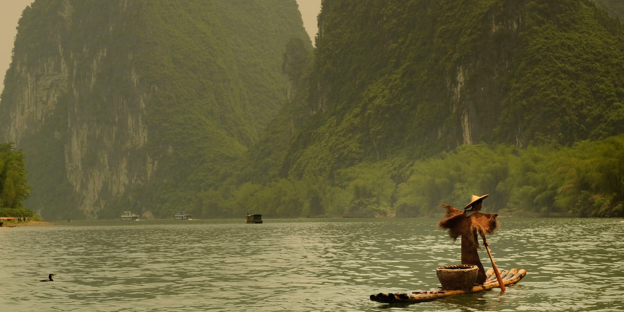 A fisherman on a bamboo raft cruises down the Li River