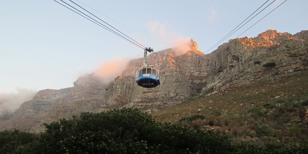 An aerial cable car ascends, heading for the summit of the iconic Table Mountain in South Africa

