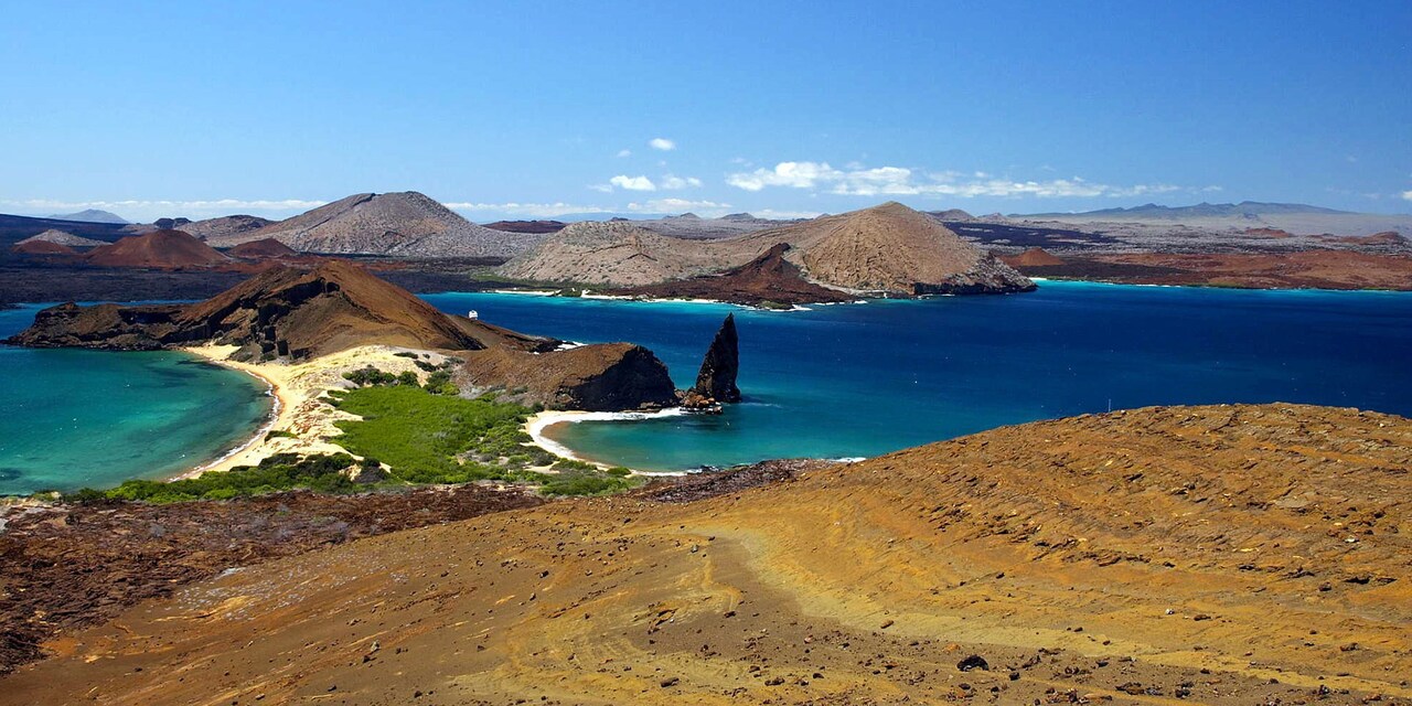 Rocky shore of Bartolome Island with blue ocean coves