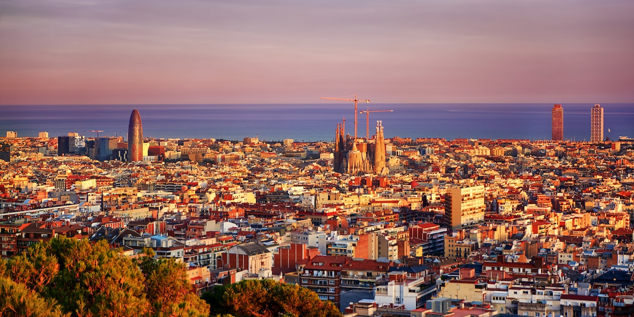 A view of the city of Barcelona with the Sagrada Famíla in the center and the Balearic Sea in the distance
