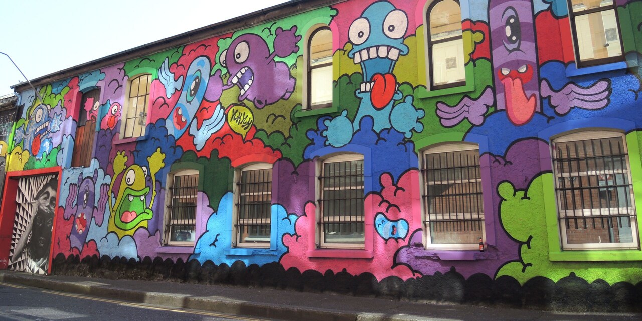 The side of a building covered in cartoon-style graffiti artwork
