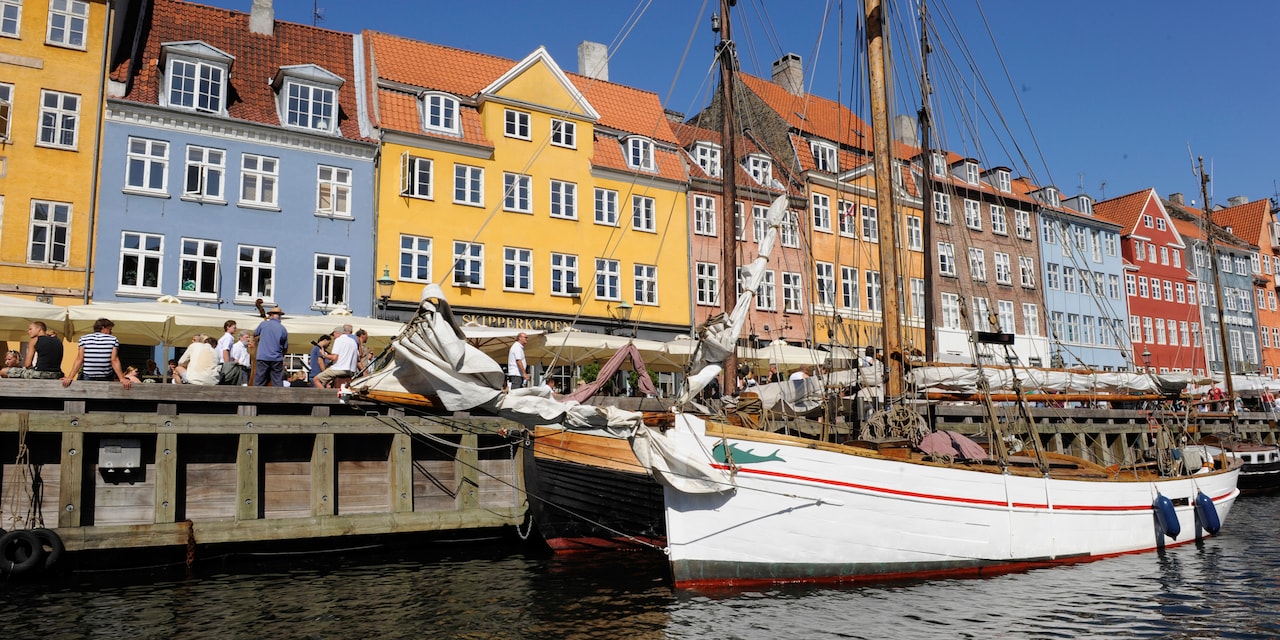 A boat docked at the Copenhagen harbor near European row houses