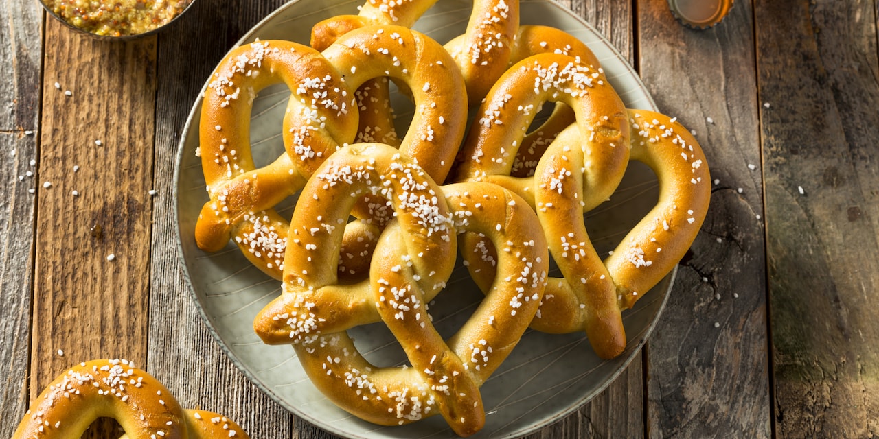 A plate with four pretzels on a wood table