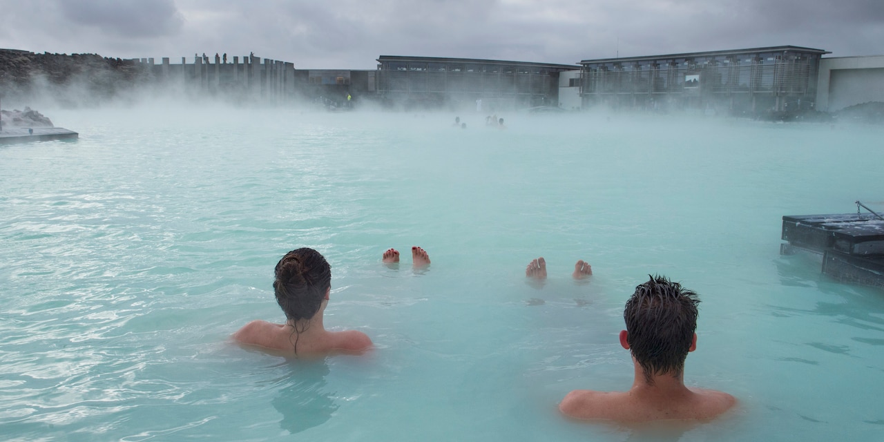 4 people enjoy soaking in the steamy waters of a natural bath