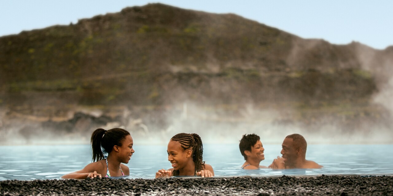 4 people enjoy soaking in the steamy waters of a natural bath