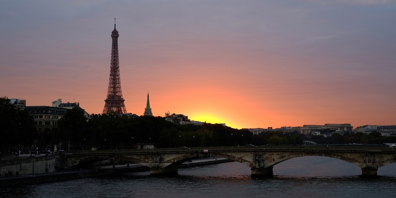 A bridge over the Seine River and the Eiffel Tower at sunset