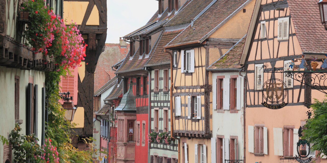 The town of Riquewihr in France featuring rustic buildings along a narrow alley