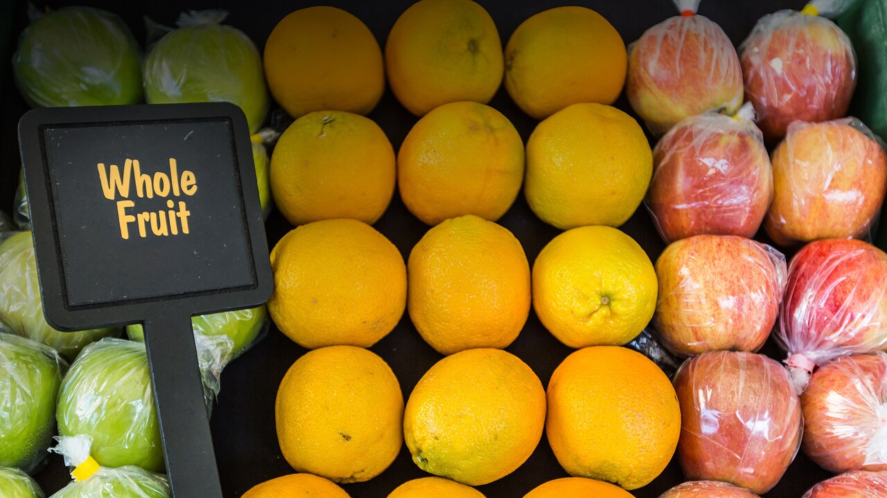 Un carro de frutas con manzanas y naranjas
