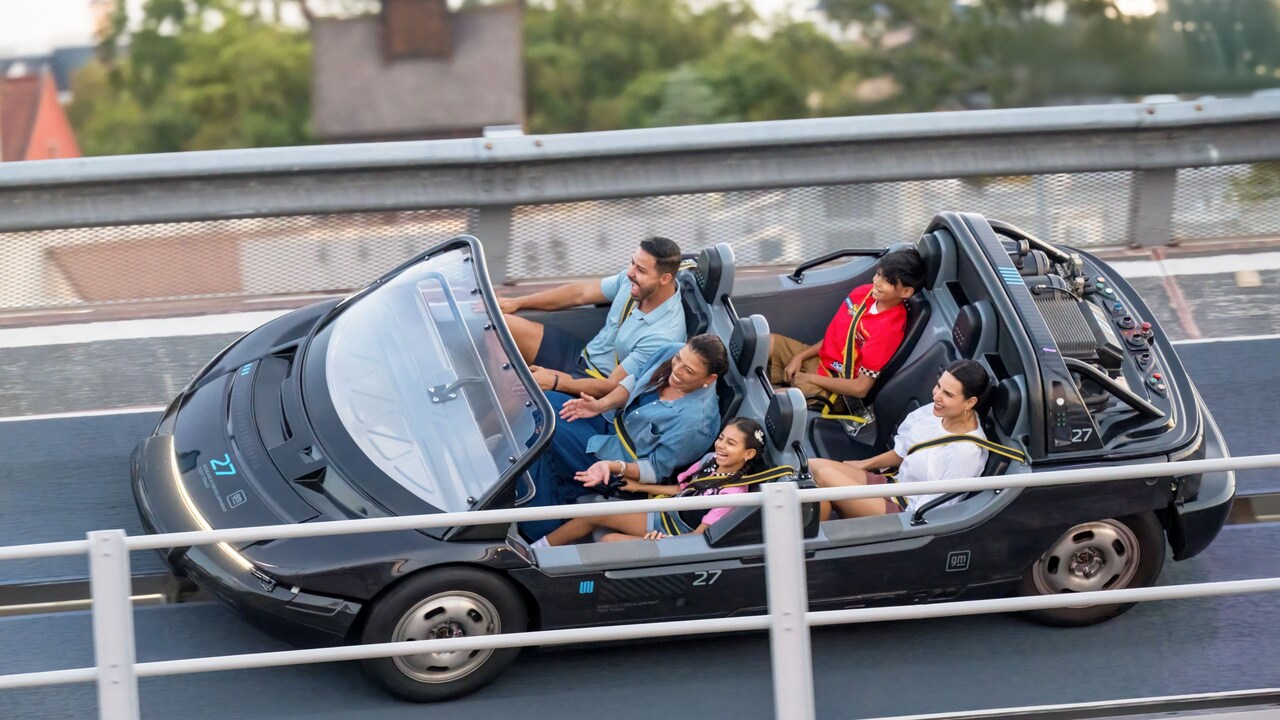 A family of 5 Guests smiling as they ride Test Track at Epcot