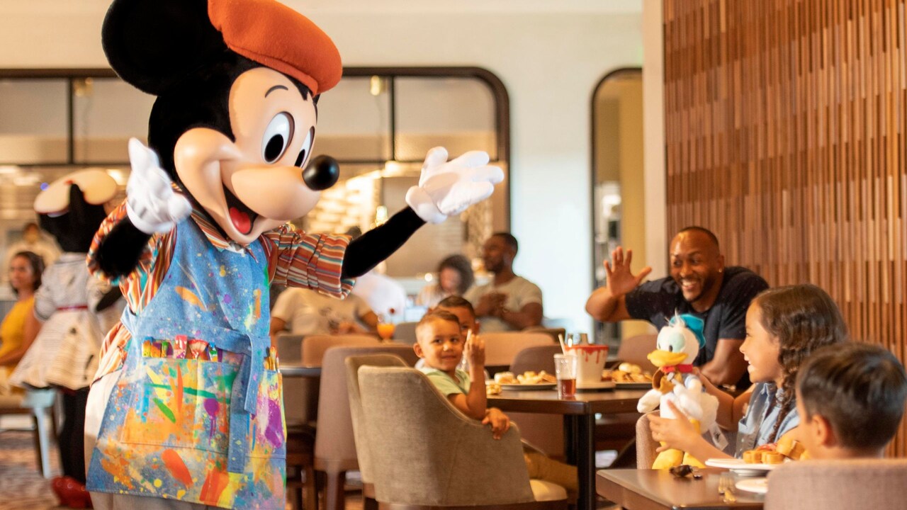 Mickey Mouse interactúa con un grupo de niños que cenan en Topolino's Terrace, Flavors of the Riviera