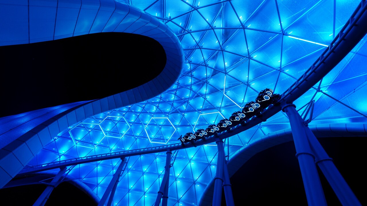 Upward view of the TRON Lightcycle / Run attraction overhang at Magic Kingdom park as a vehicle cart rides by