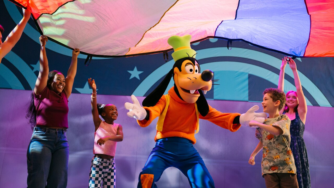 Goofy dancing with Guests under a large parachute
