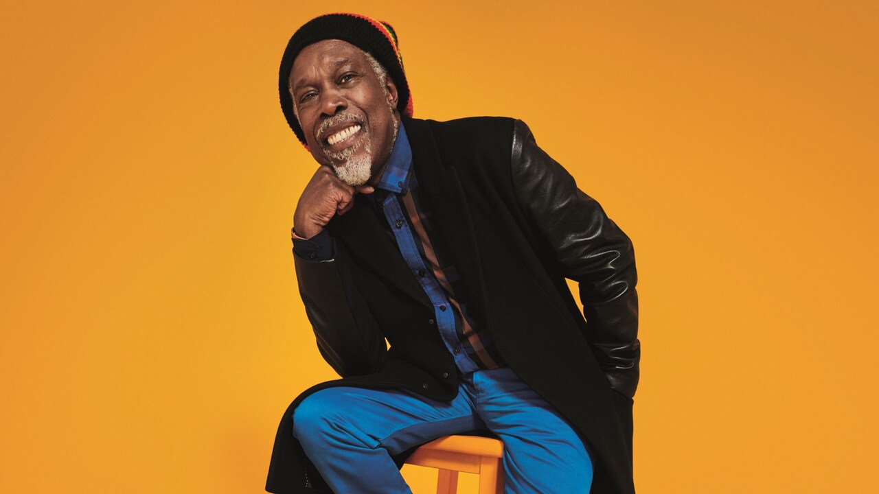 Billy Ocean sitting on a wooden stool