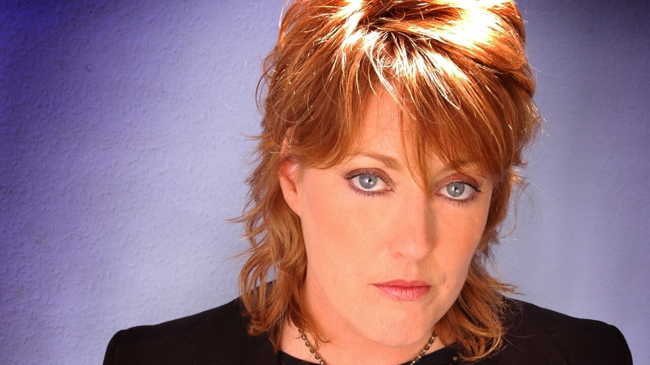 Katrina formally of Katrina and the Waves posing with her hands at her sides