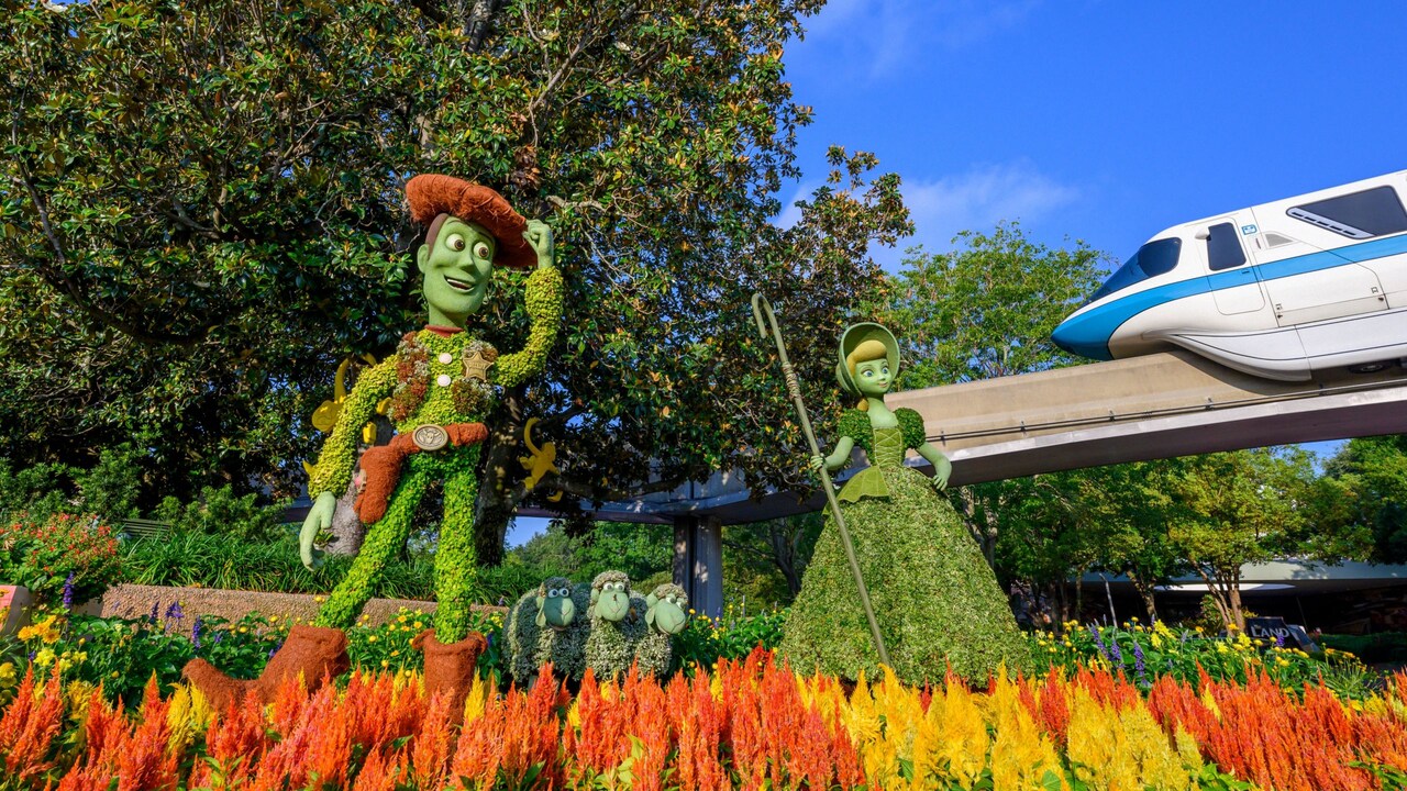 A garden with 3 topiaries featuring Woody, Bo Peep, Billy, Goat and Gruff from ′Toy Story′ near the monorail