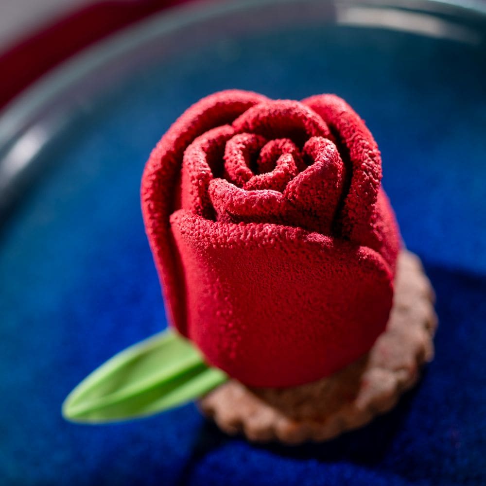 Milk Chocolate Rose with raspberry and rose center atop a cookie on a plate