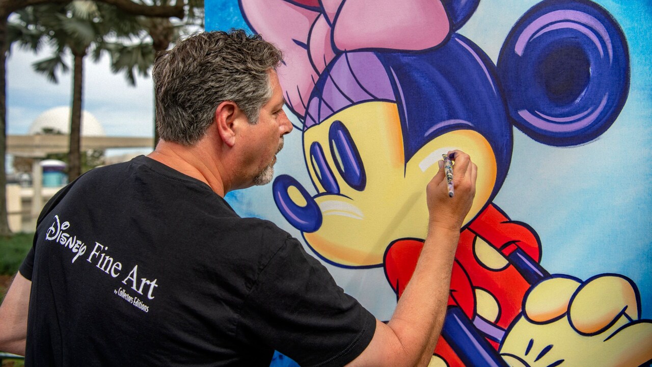 A man paints a colorful portrait of Minnie Mouse 