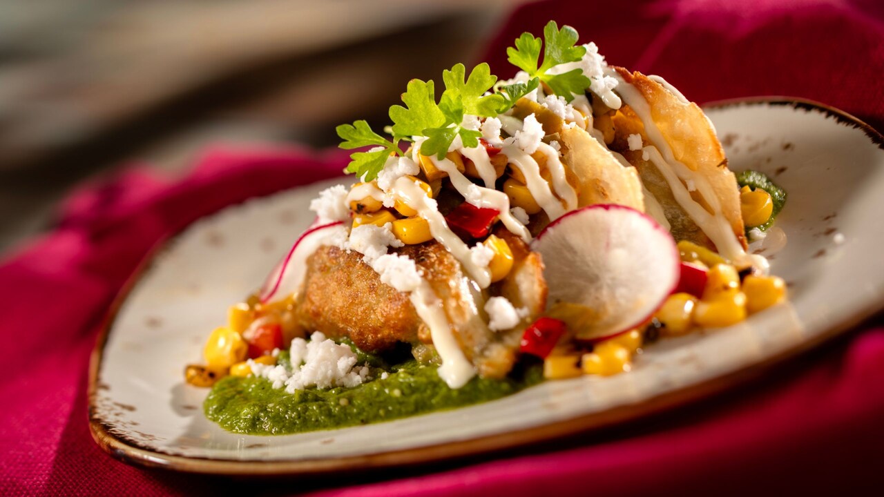 Street corn style dumplings topped with corn, cheese, sauce and garnish