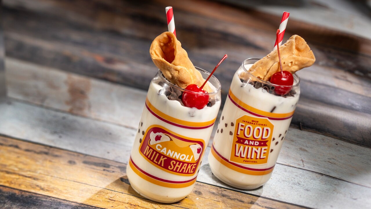 2 milkshakes, each topped with one cannoli shell, a maraschino cherry and chocolate shavings
