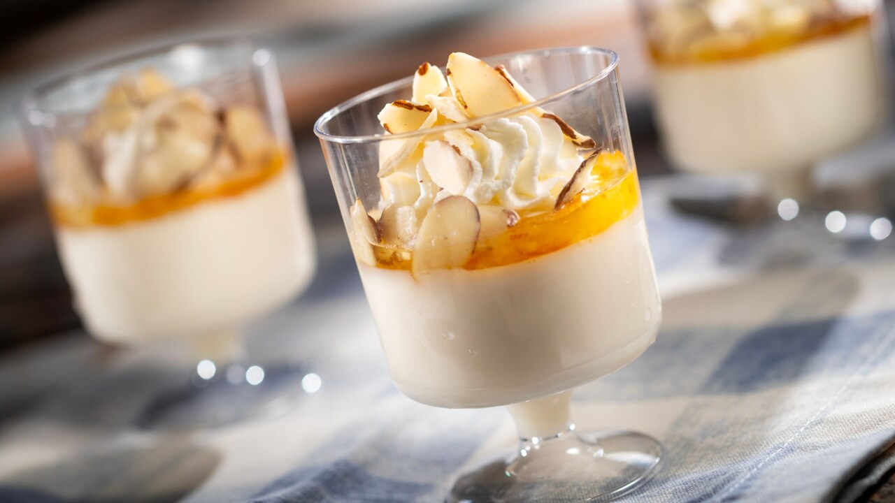 Almond Panna Cotta, with orange marmalade, whipped cream and candied almonds in a dessert glass