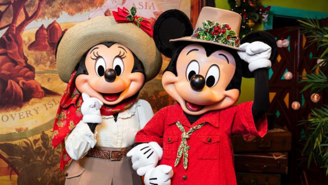 Minnie Mouse and Mickey Mouse in explorer outfits posing together during the holiday season