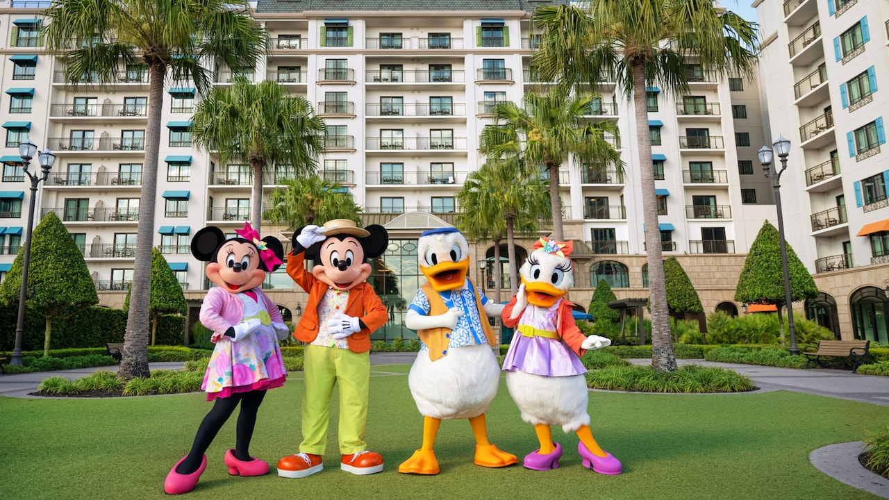 Minnie Mouse, Mickey Mouse, Donald Duck and Daisy Duck dressed in spring outfits posing in front of Disney’s Riviera Resort
