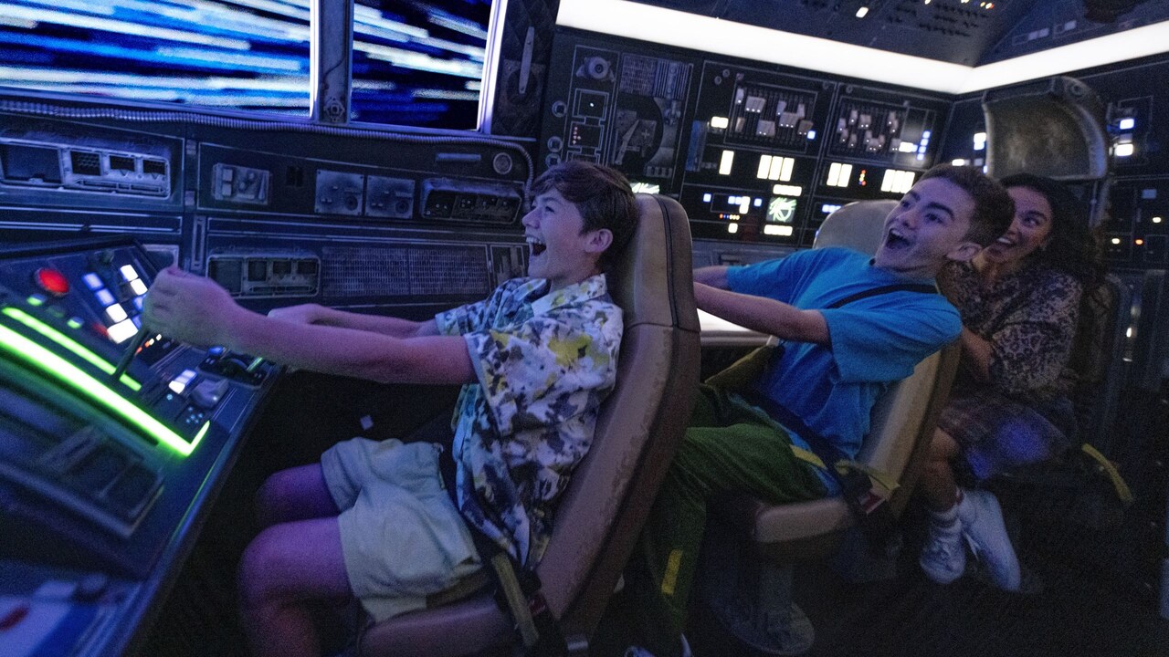 Una familia de 3 integrantes dentro de la cabina de la atracción Millennium Falcon Smugglers Run
