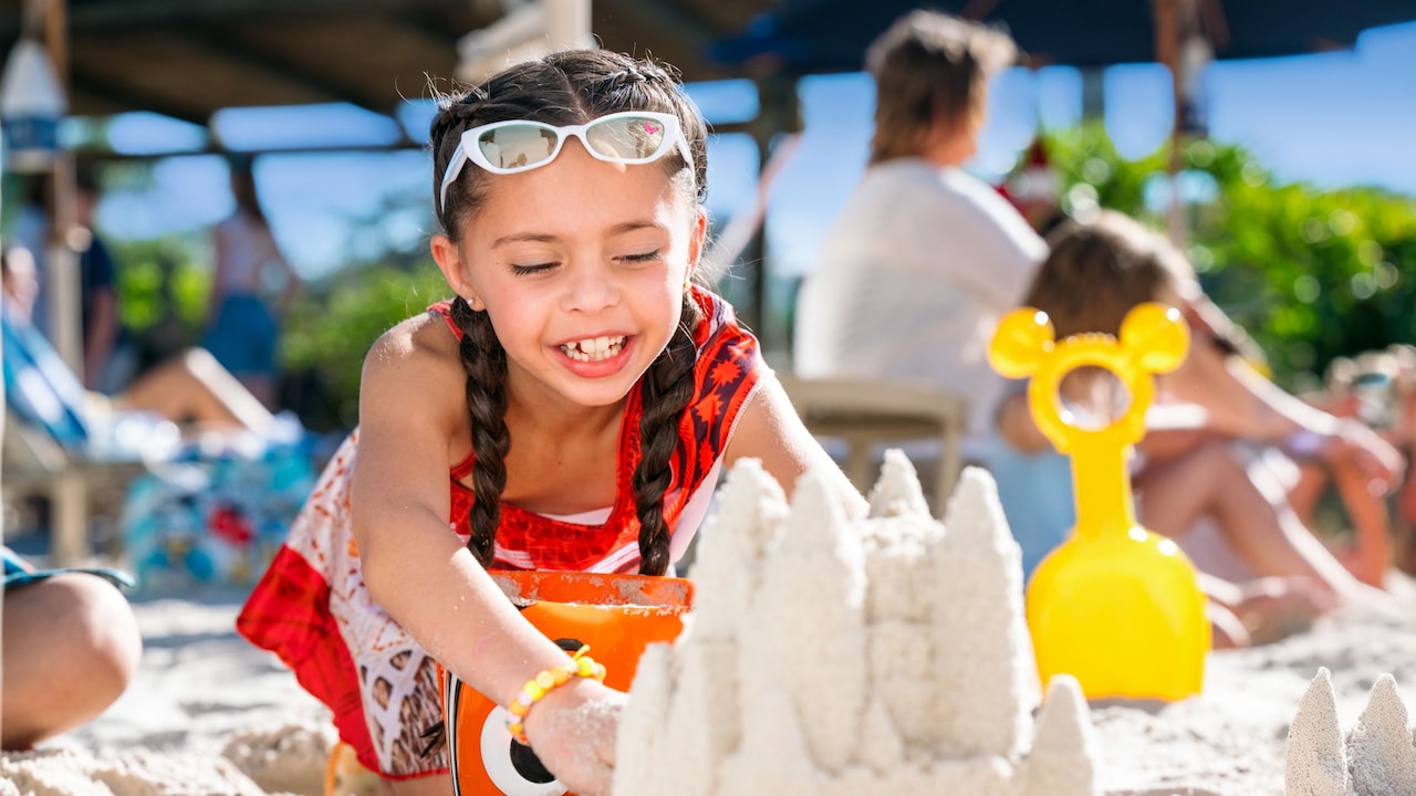 A young girl building a sandcastle on the beach