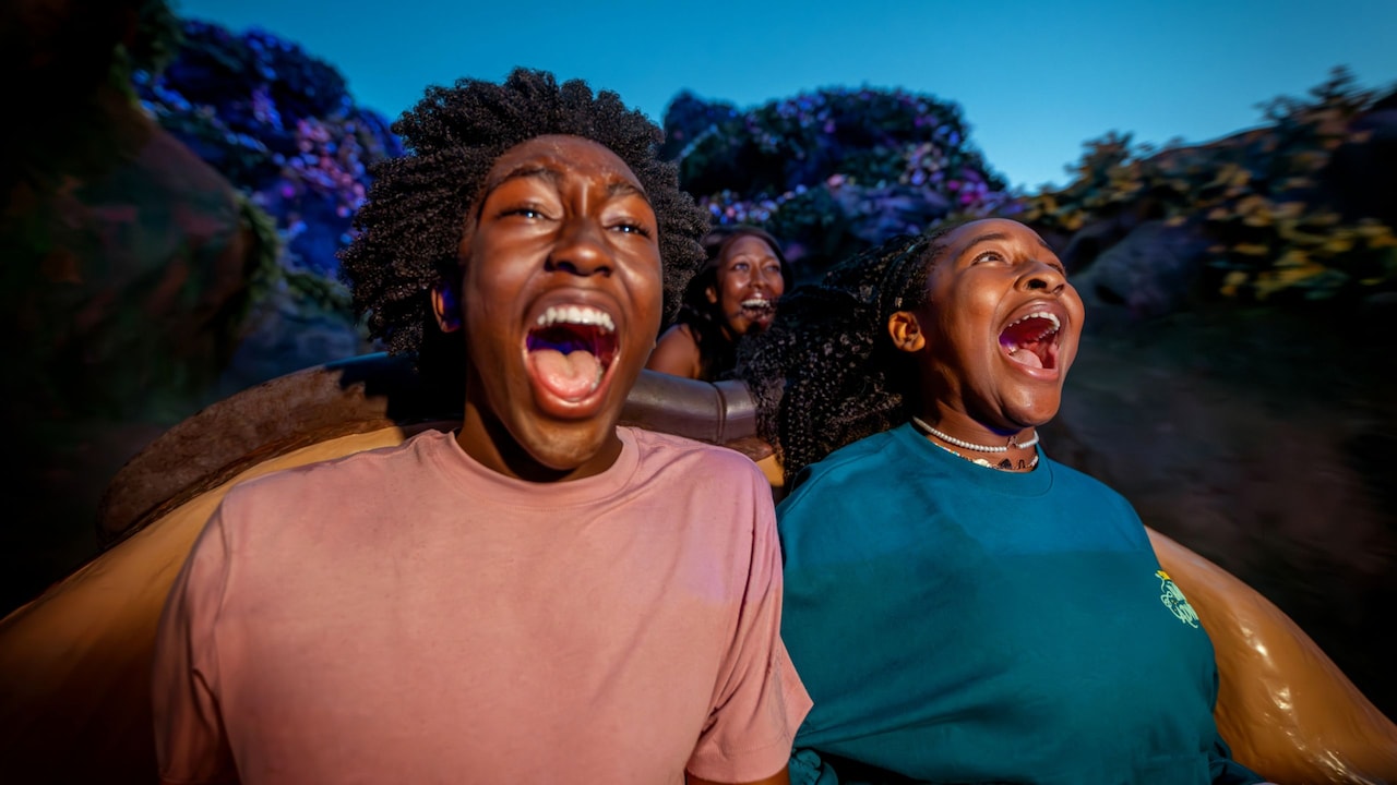 Guests with mouths agape, riding Seven Dwarfs Mine Train at night