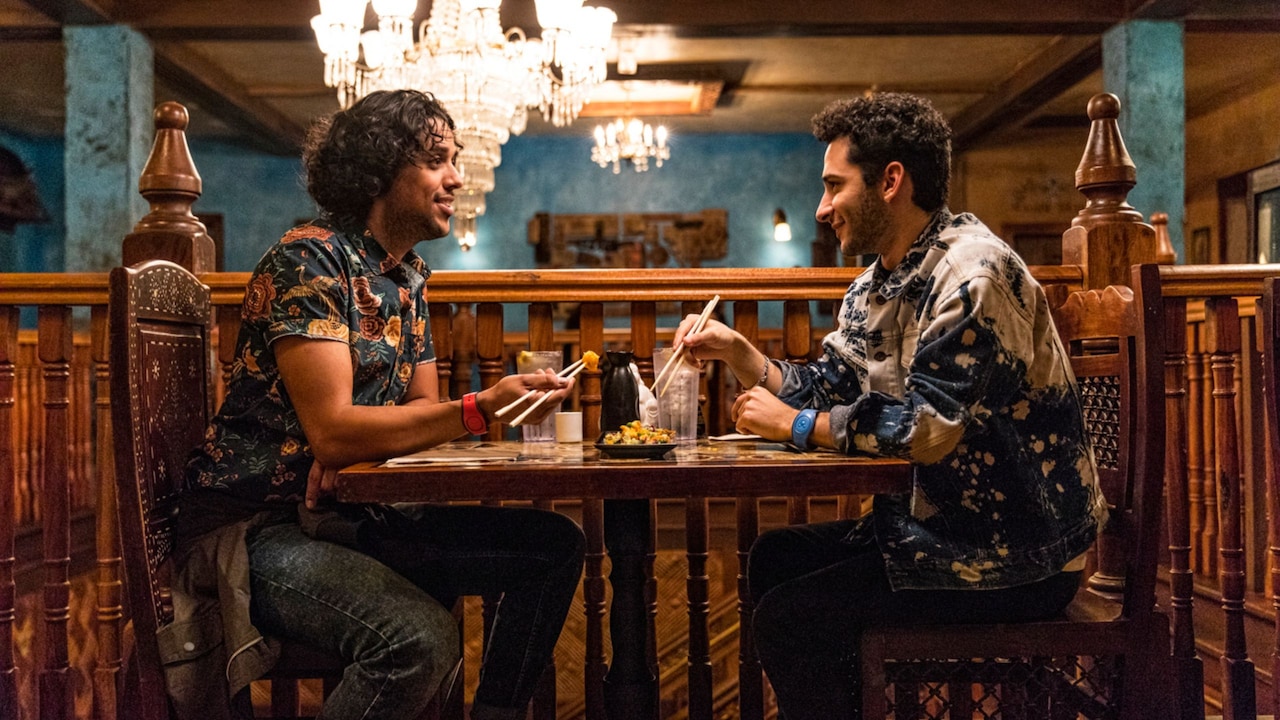 Two men facing each other eating at the Yak & Yeti restaurant in Disney's Animal Kingdom Theme Park