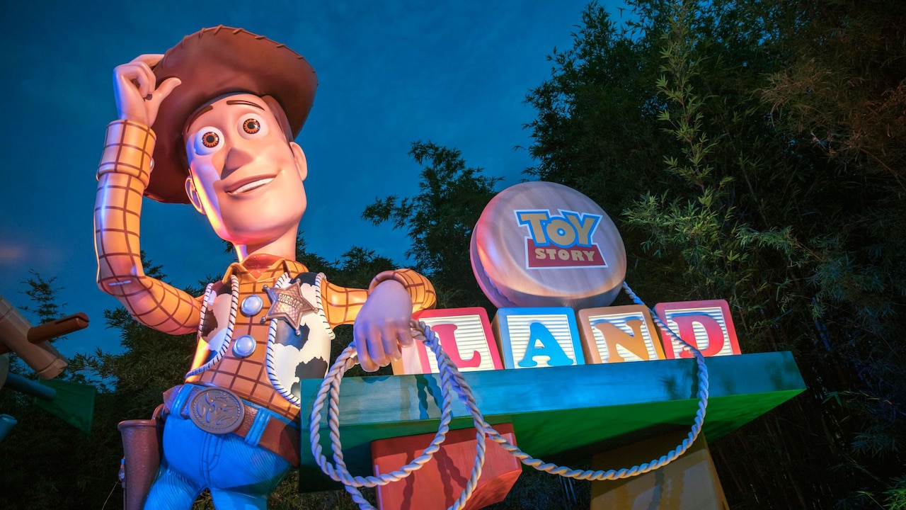 The entrance to Toy Story Land in Disney's Hollywood Studios theme park, featuring oversized toys and a giant Woody statue