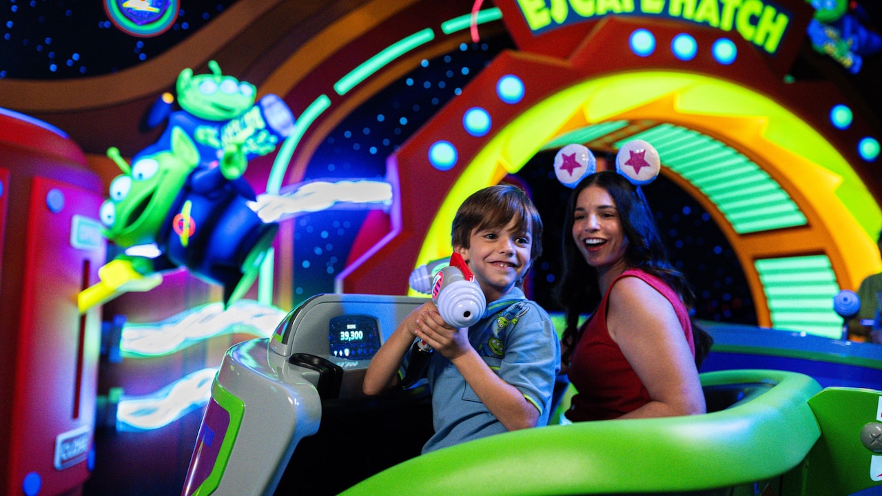 An adult and young child riding Buzz Lightyear’s Space Ranger Spin