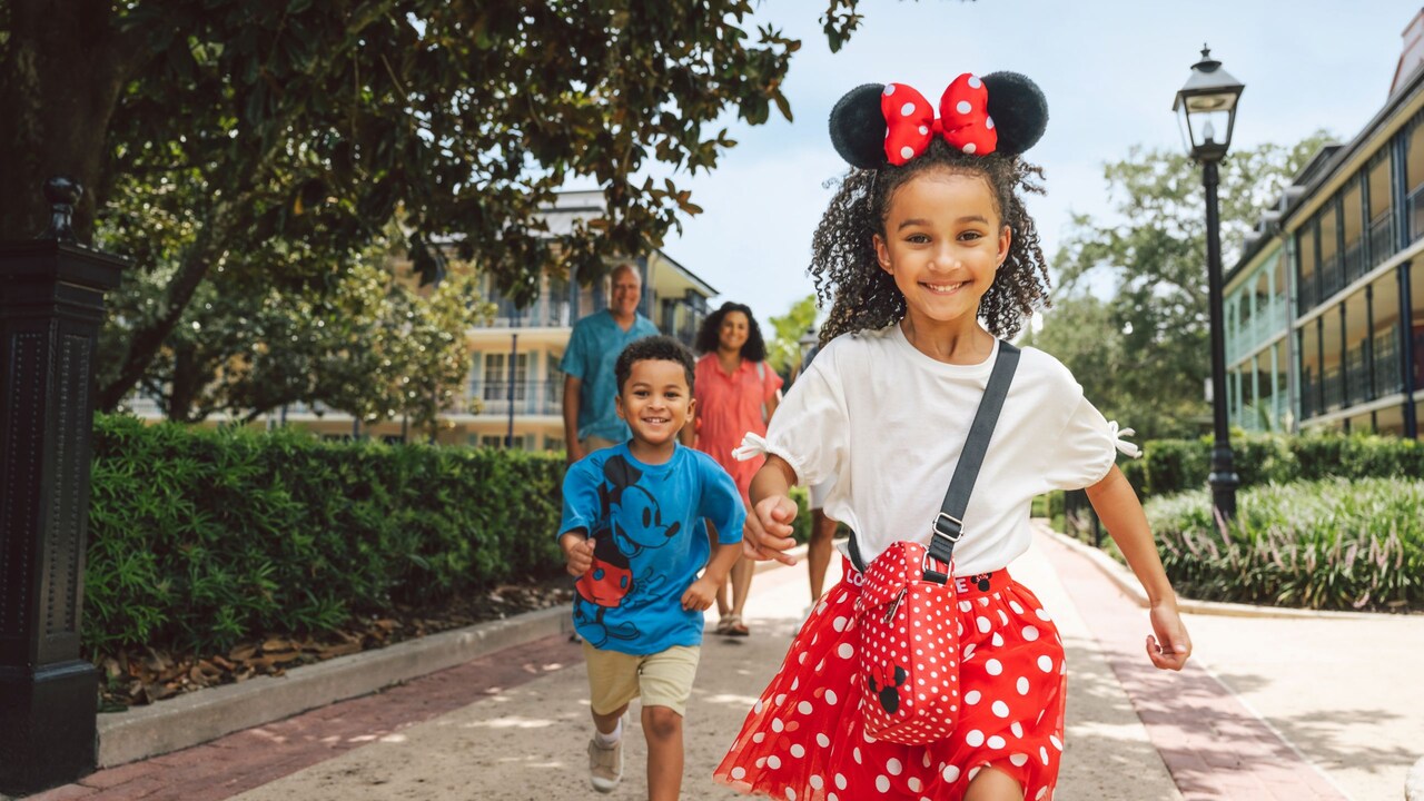 Two children running ahead of their parents as they walk through Disney’s Port Orleans Resort
