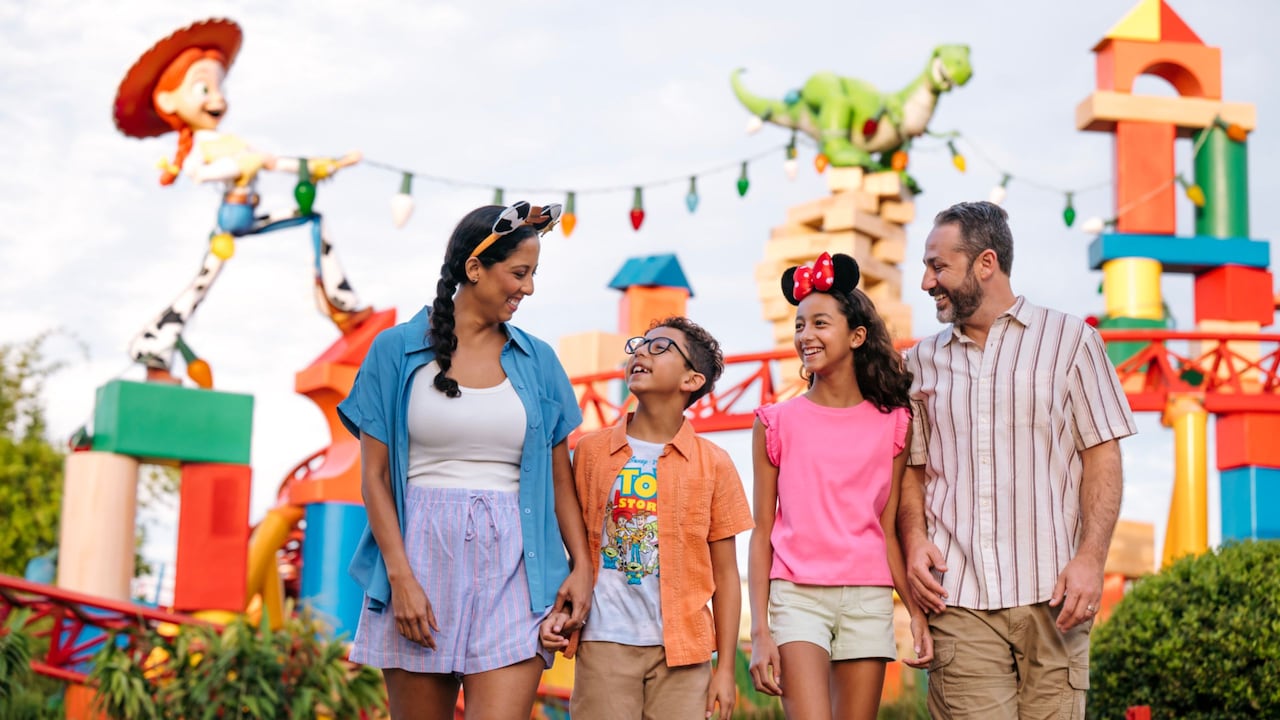 A young family of 4 walking through Toy Story Land at Disney’s Hollywood Studios theme park