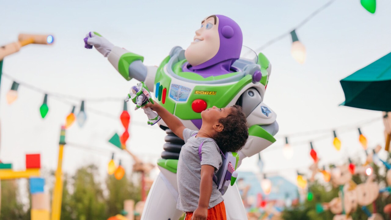 Un niño parado junto a Buzz Lightyear en Toy Story Land