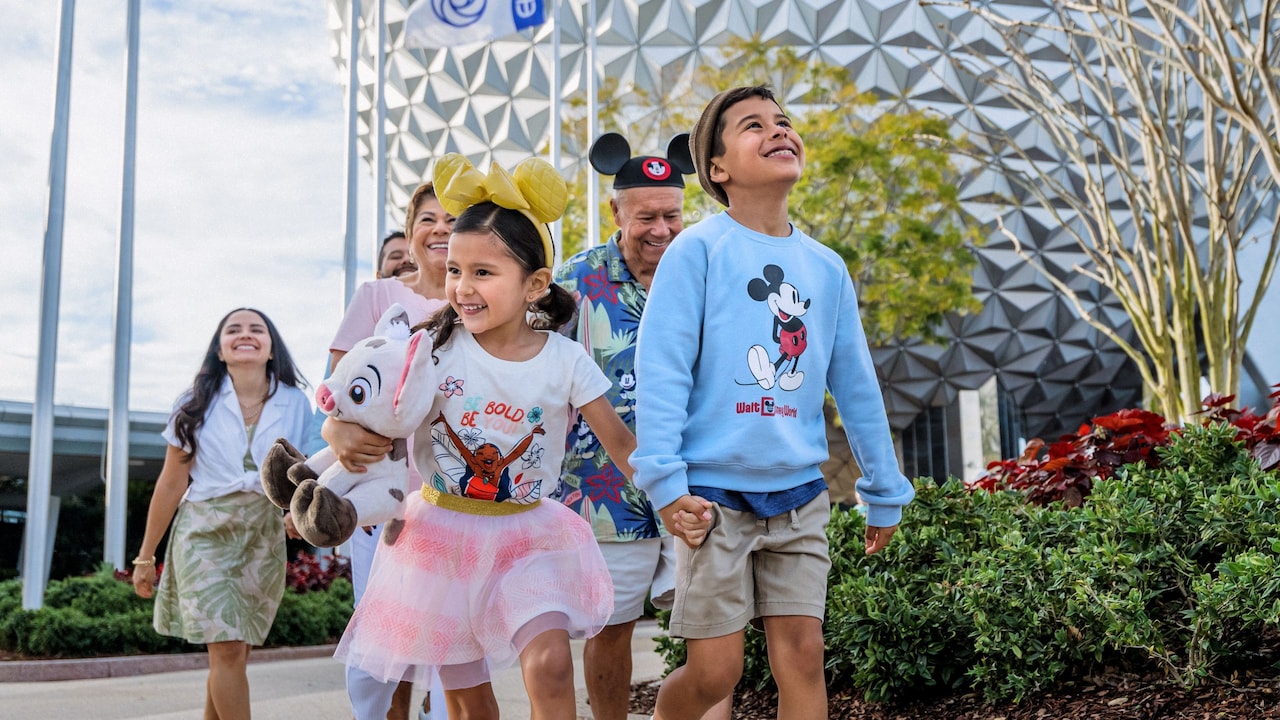 A multi generational family walking near Spaceship Earth at Epcot