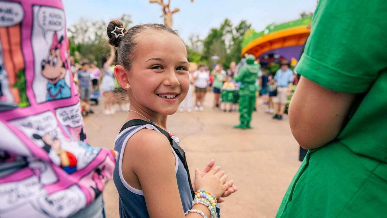  A girl smiling over her shoulder while in Toy Story Land 