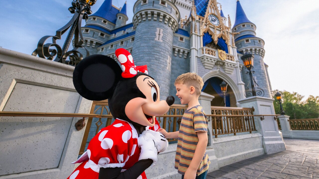  Minnie Mouse greeting a young boy in front of Cinderella Castle at Magic Kingdom park