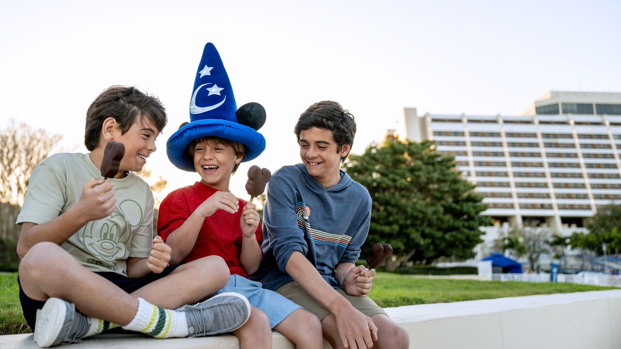 Three boys eating Mickey Mouse ice cream bars in front of Disney’s Contemporary Resort