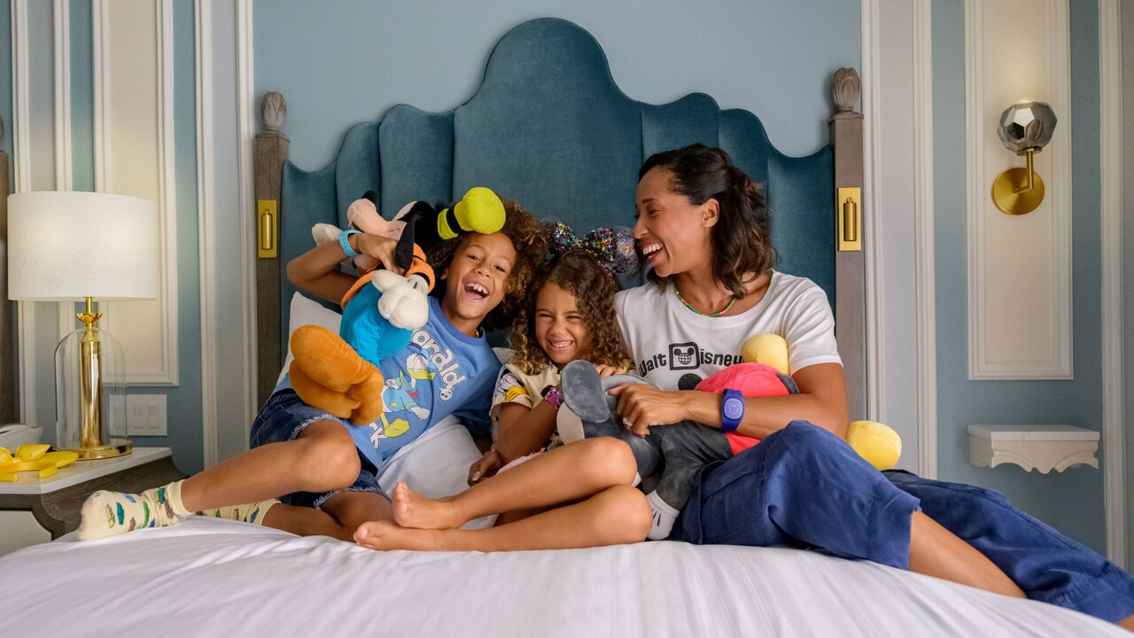 A family of 3 relaxing together in their Resort hotel room at Walt Disney World