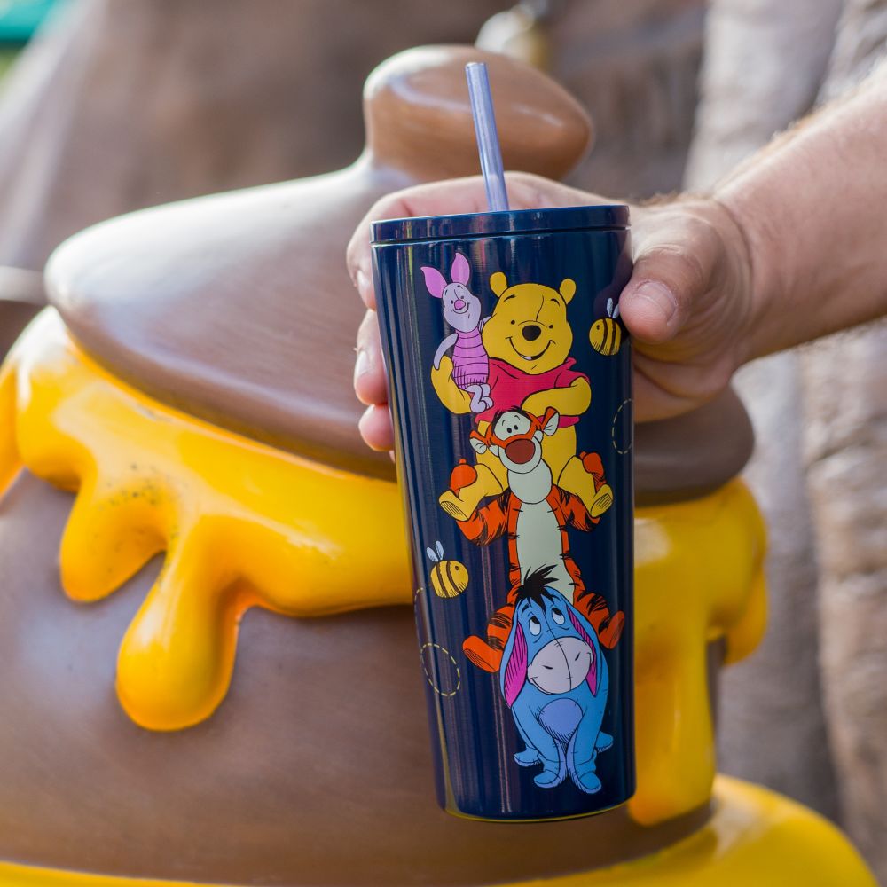 A Guest holding a travel cup featuring Winnie the Pooh characters