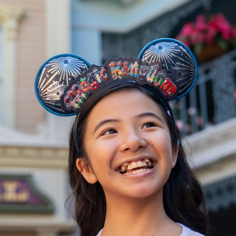 A girl wearing a Magic Kingdom themed Mickey Mouse ear headband