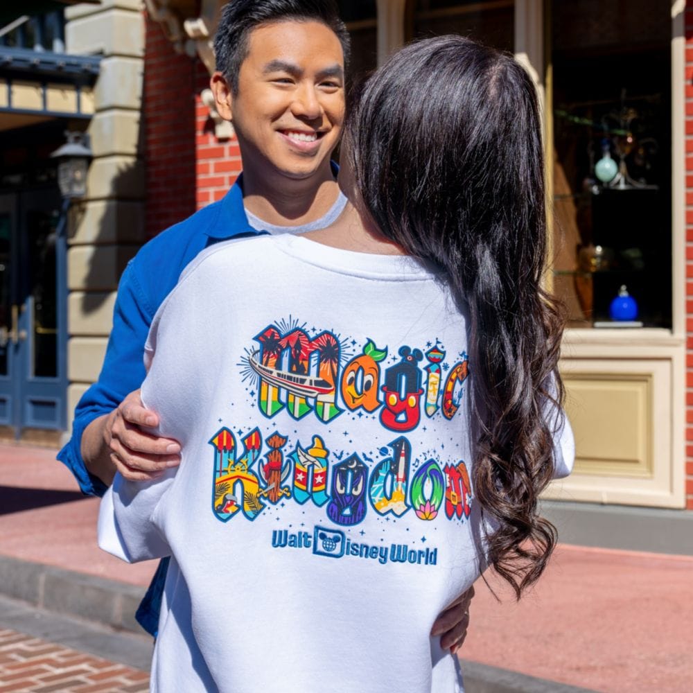 A man embracing a woman wearing a Magic Kingdom sweatshirt