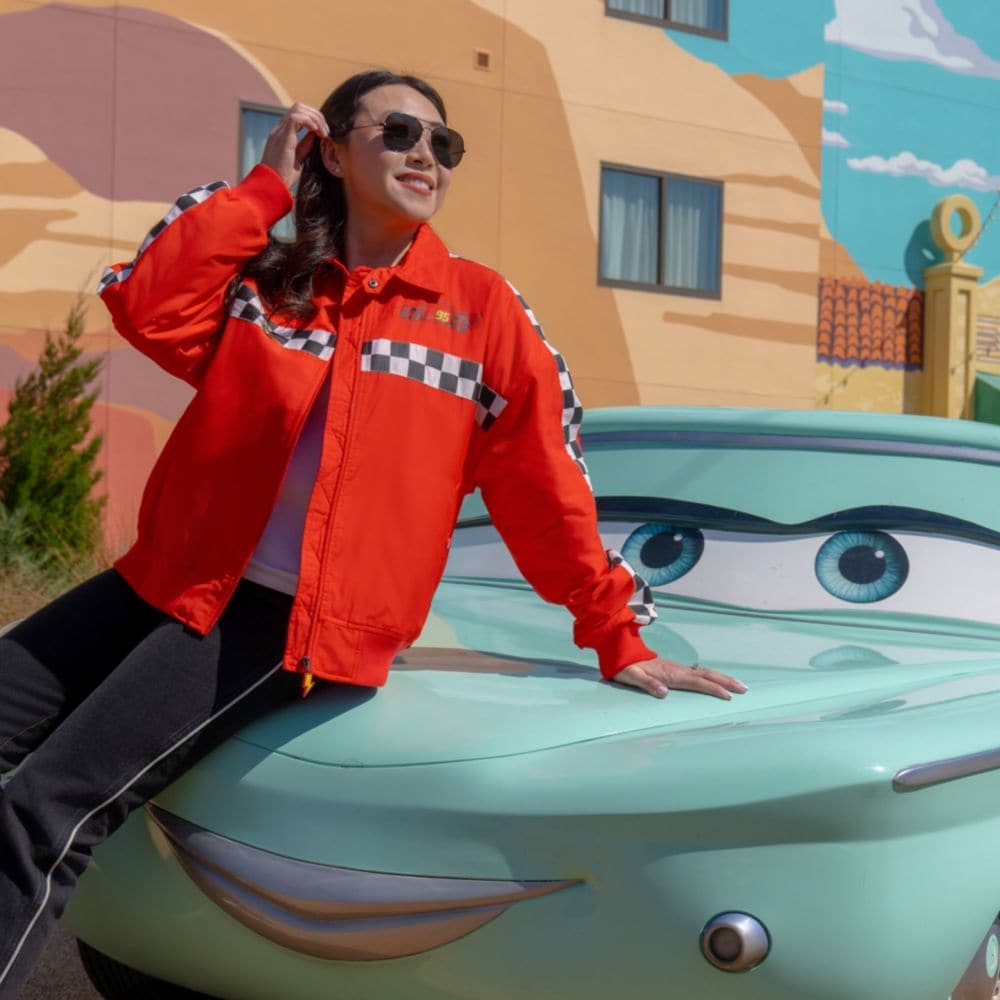 A Guest leaning on a life size character statue of Flo at Disney's Art of Animation Resort