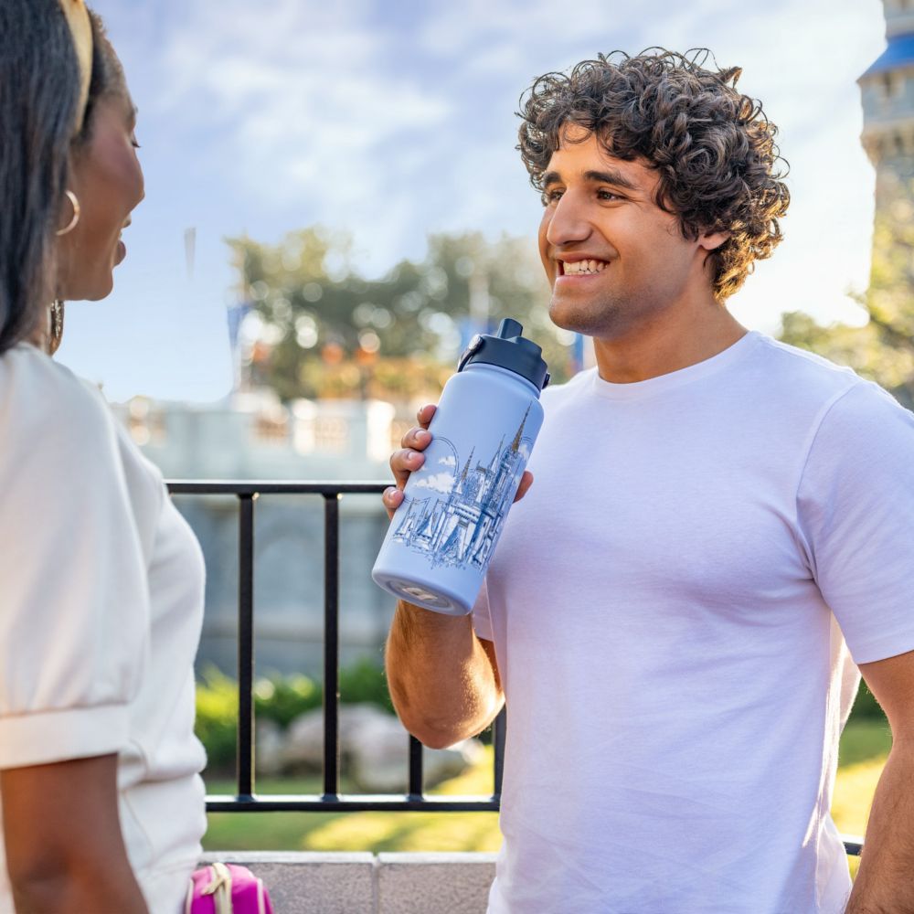 A woman taking a selfie while wearing a sweatshirt featuring Cinderella Castle