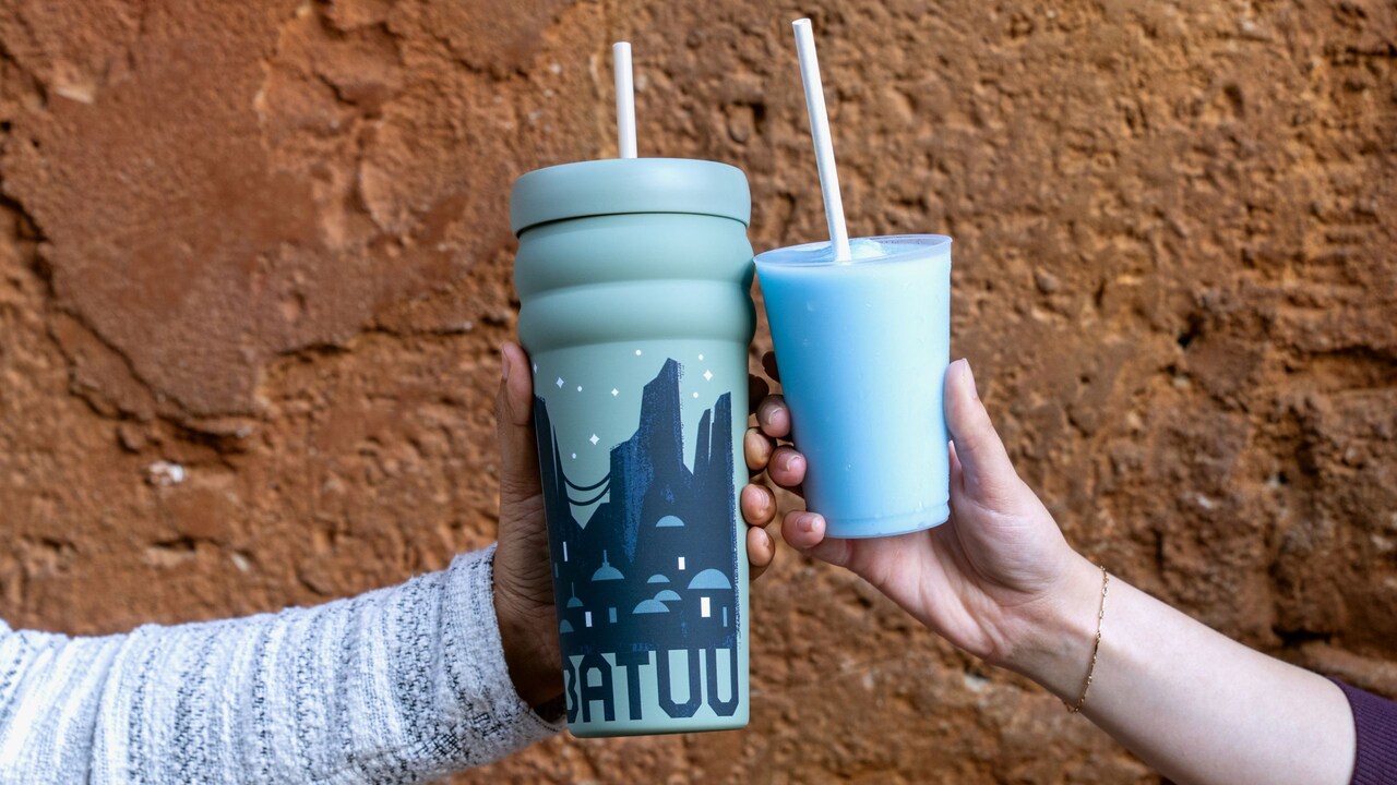 Two hands holding drinks together at Disney's Hollywood Studios theme park