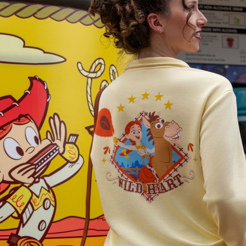 A Guest looking over her shoulder while wearing a Toy Story themed sweatshirt at Disney's Hollywood Studios theme park