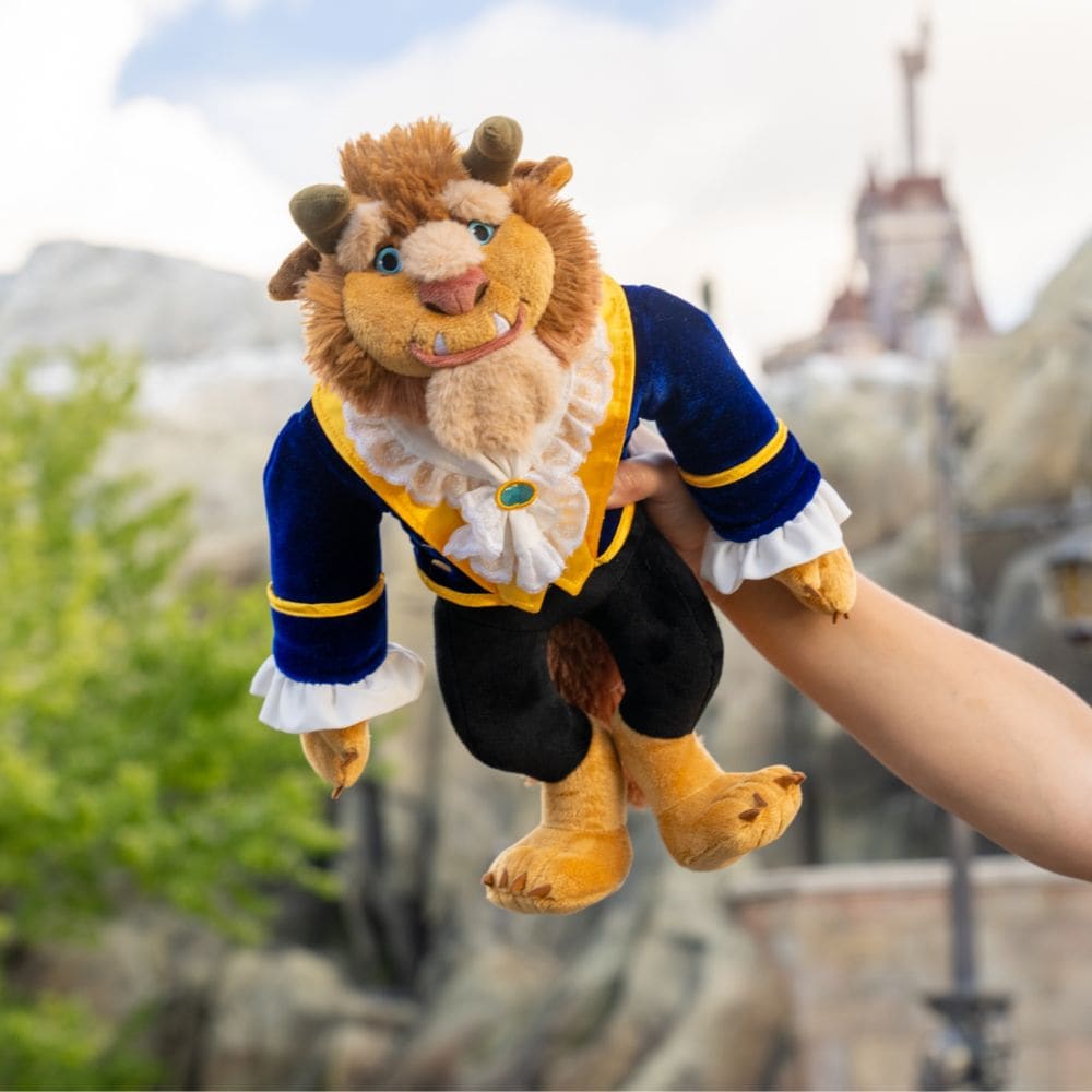 A hand holding up a Beast plush toy
