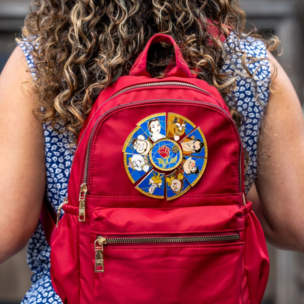 A woman wearing a backpack with a Beauty and the Beast patch
